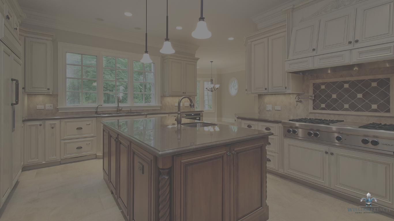 A modern kitchen features cream-colored cabinets, stainless steel appliances, a large center island with dark countertops, and pendant lighting. The room is well-lit with natural light from a large window above the sink and recessed ceiling lights.